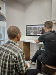 Dr Nejat showing an All on Four patient their dental scans